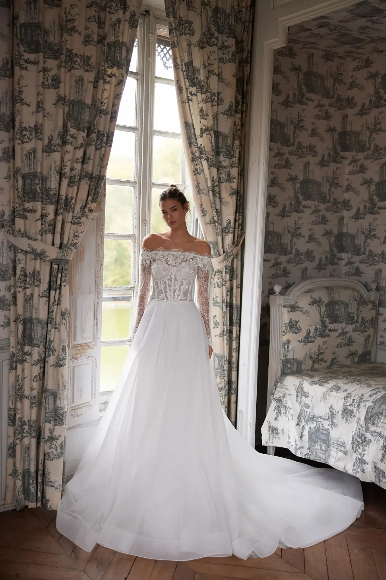 Lisette ejtett vállú A-vonalú menyasszonyi ruha hosszú csipkeujjal és csillogó tüll szoknyával a Holdfény Szalonban, Cegléden